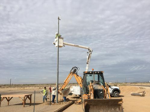 City Installing Pole For The Weather Station At Field